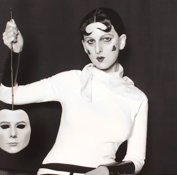 Black and white photo of a woman taking of her mask