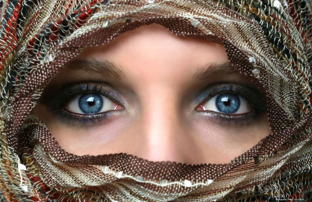 A blue eyed woman wearing a head cover 