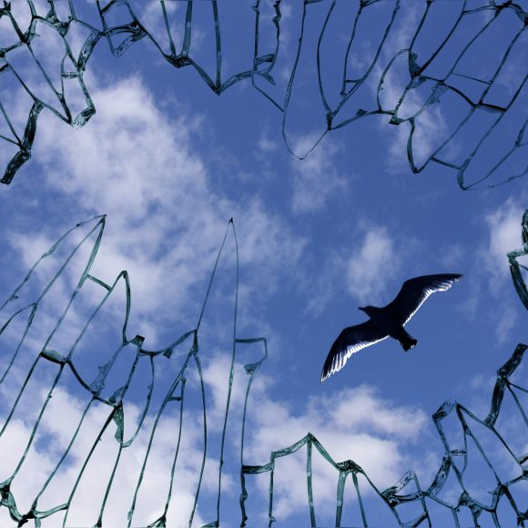 Broken,Window,Glass,With,View,To,Blue,Sky,-,Symbol